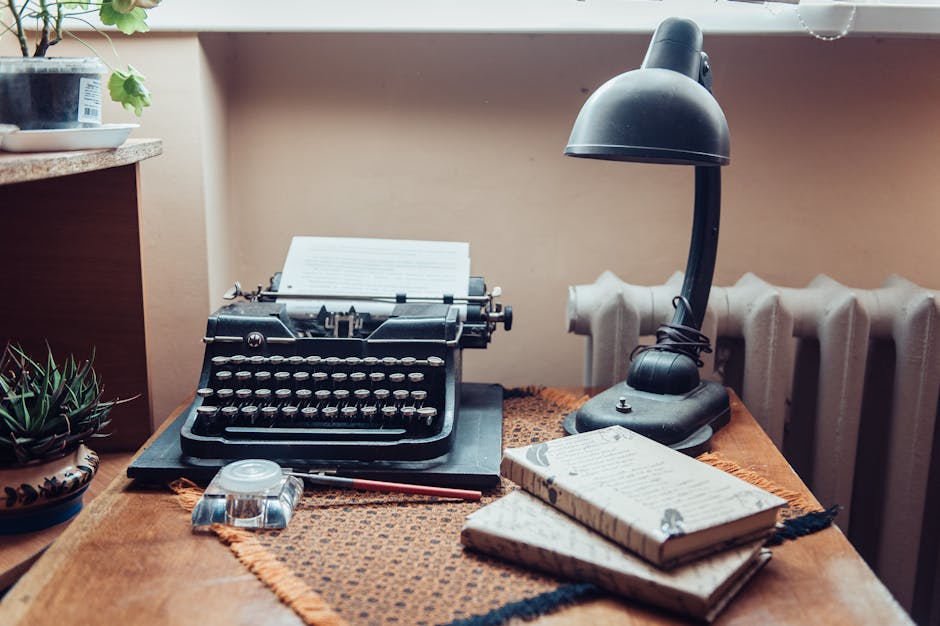 A cozy workspace featuring a vintage typewriter, desk lamp, and wooden desk setup.