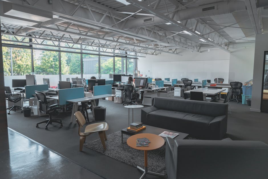 A spacious modern office with desks, computers, and natural light creating an inviting work environment.