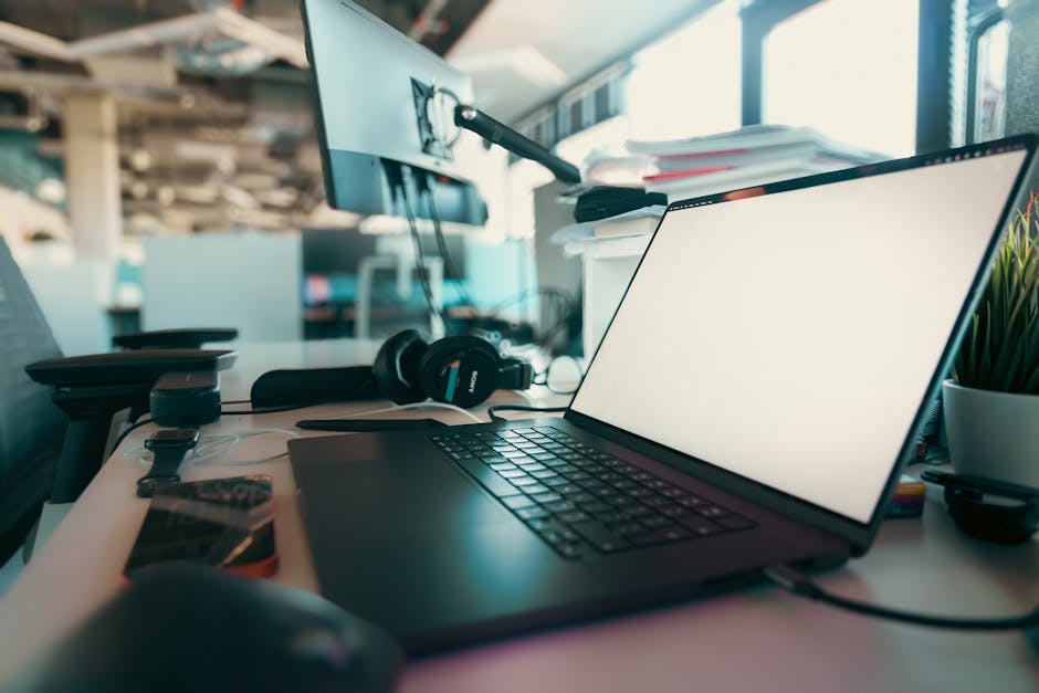 A contemporary office desk setup featuring a laptop, monitor, and headphones for a productive work environment.